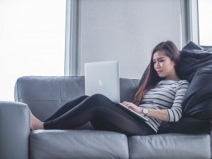 woman on sofa with laptop