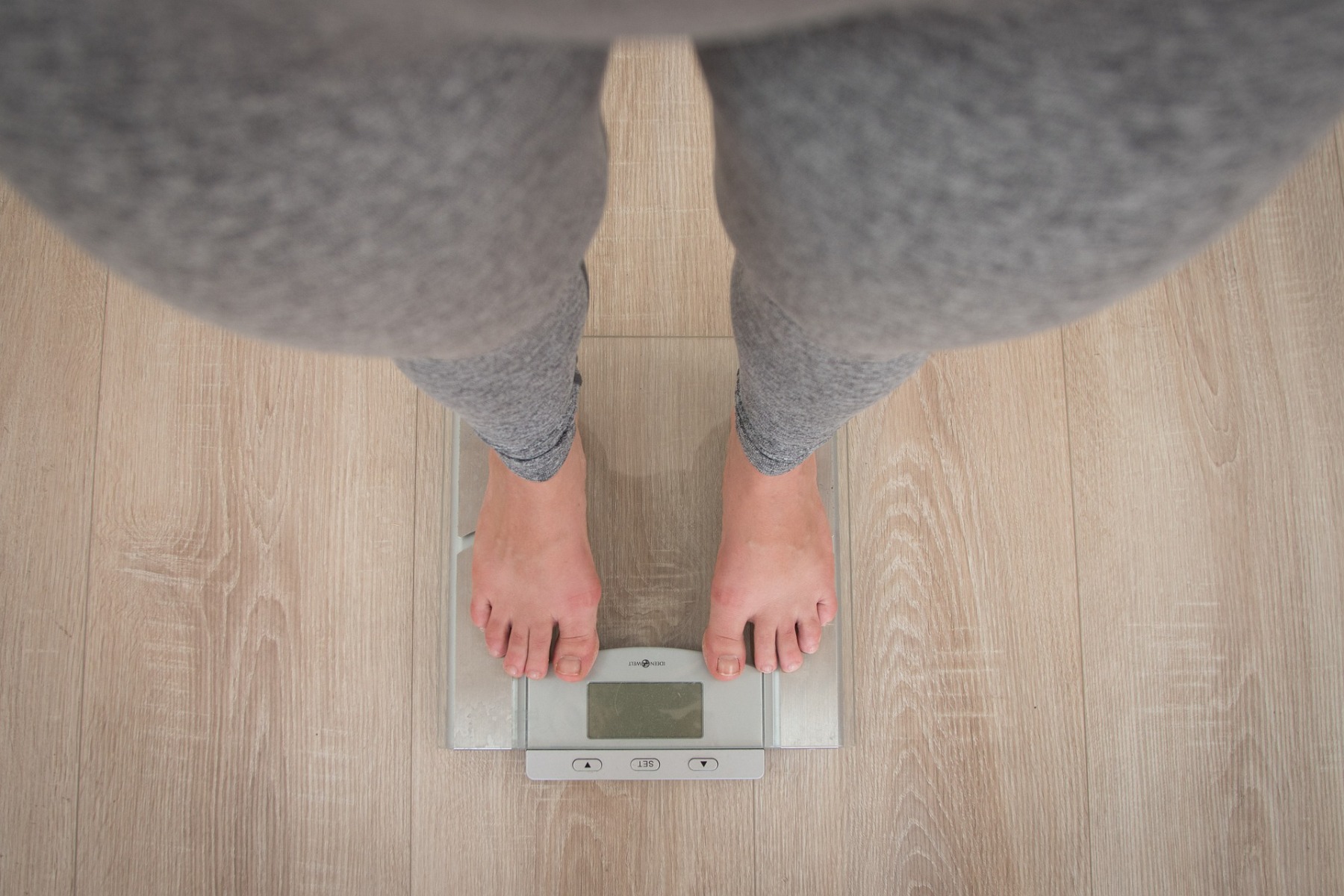 woman stood on bathroom scales to check her weight